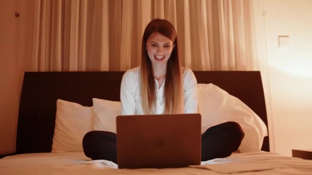 Mulher feliz usando laptop para bate-papo por vídeo durante a noite — Vídeo de Stock
