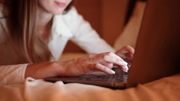 Close up of woman resting on bed and typing on laptop — Stock Video