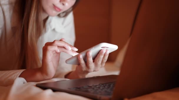 Blisko kobiety za pomocą telefonu komórkowego i laptopa w pokoju hotelowym — Wideo stockowe