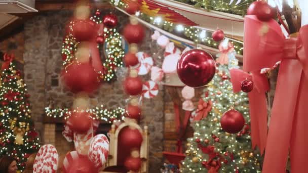 Veel geschenkdozen en kerstversieringen onder een prachtige versierde kerstboom met in de woonkamer. Kerstversieringen met filmische details van Bauble On Tree, Relaxing Scene Thuis of Store — Stockvideo