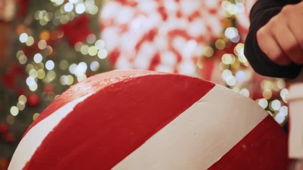 Großaufnahme weiblicher Hände mit Pinsel, Mädchen malt Weihnachts- oder Neujahrsdekoration in weiß und rot. Das Konzept der Vorbereitung auf Weihnachten und Neujahr. — Stockvideo