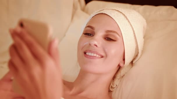 СМС жінки на смартфоні під час відпочинку в ліжку — стокове відео