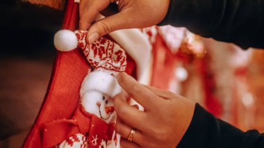 Şöminenin üzerinde bir kardan adam asılı kırmızı çorap, kadınlar