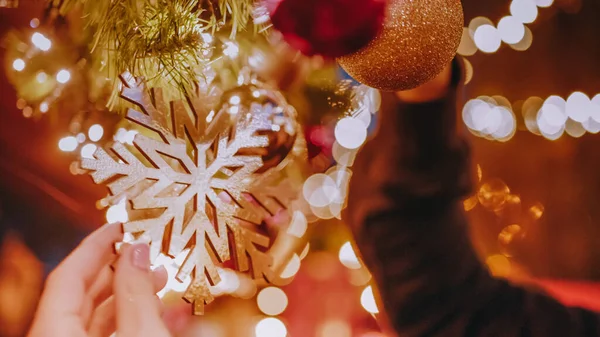 Close-up ของมือตกแต่งต้นคริสต์มาสกับลูกบอลบน ba — ภาพถ่ายสต็อก