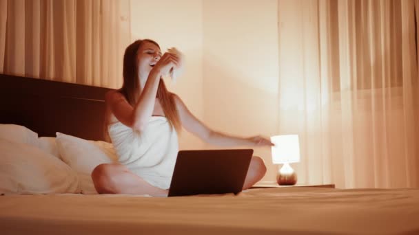 Mulher acenando com fã de euro enquanto sentado na cama — Vídeo de Stock