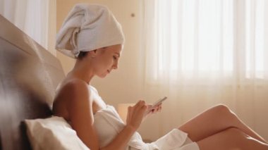 Orta yaşlı bir kadın koltukta bacak bacak üstüne atmış bir şekilde oturuyor. Cep telefonundan iyi haberler geliyor. SMS 'in çığlığı sevinçten uçuyor. Başarılı oyun ve kumar, açık artırma online teklif, parasal kazanç, internet piyango konsepti