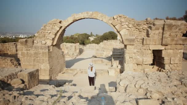 Žena v letním klobouku procházky mezi zříceninami starověkých budov — Stock video