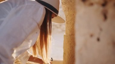 Arkeolog antik tapınakta fırça ve harita kullanıyor.