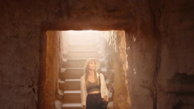 Elinde fotoğraf makinesi olan kadın antik mirası keşfediyor.