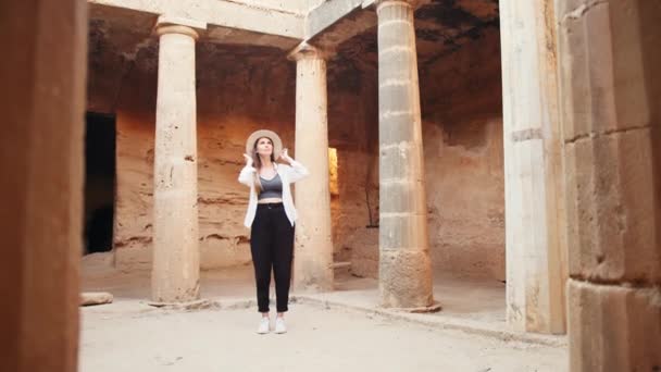 Жінка стоїть серед колон стародавнього храму — стокове відео