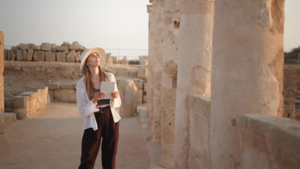 Жінка в капелюсі вивчення історичних будівель — стокове відео