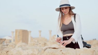 Eski yıkılmış tapınağı inceleyen kadın.