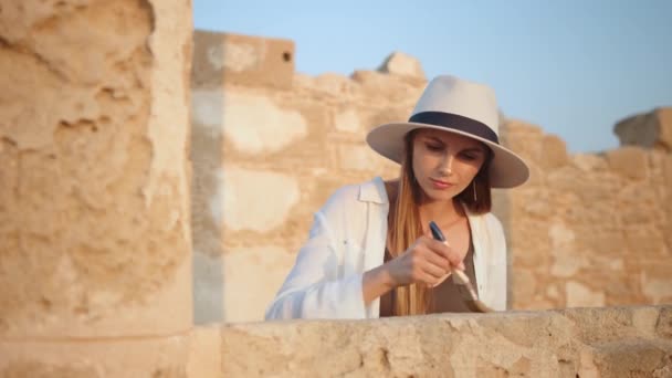 Жінка використовує пензлик під час риття стародавнього храму — стокове відео