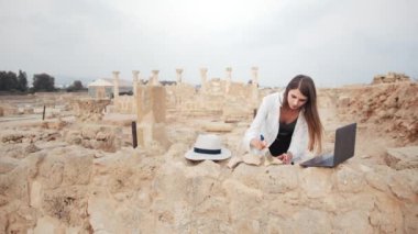Antik tapınağı kazarken dizüstü bilgisayarla çalışan kadın