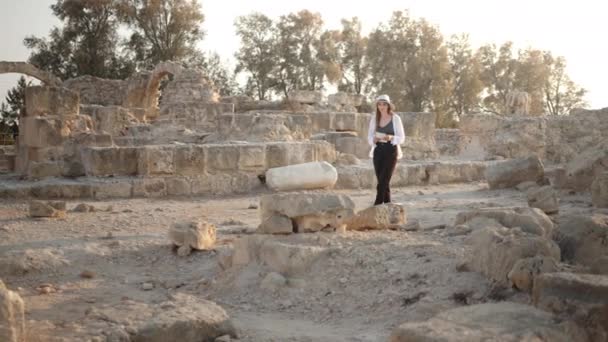 Arqueólogo feminino andando entre templo antigo arruinado — Vídeo de Stock