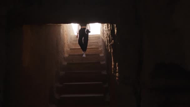 Arqueólogo subindo escadas do templo antigo. Visão traseira do arqueólogo feminino em chapéu de verão e roupas andando em escadas do templo antigo. Descoberta de edifícios históricos — Vídeo de Stock