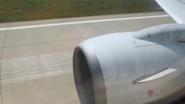Pohled z okna letadla pohybujícího se na letišti. Připravuji se na odlet. Pohled na turbínu letadla a vypnutou dráhu. Vzletový moment letadla za letu, pohled z okna letadla, — Stock video