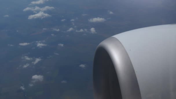 Hermosa vista del cielo y el motor a reacción fuera de la ventana del avión comercial mientras flota en el cielo de la atmósfera a destino. Vista del cielo azul con nublado. Concepto de industria aeroespacial y del transporte — Vídeos de Stock