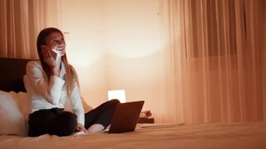 Mutlu kadın akşam evde cep telefonu konuşuyor. Geceleri gülümseyen kadın arama telefonu portresi. Yatakta cep telefonuyla yatan neşeli insan. Neşeli kadın evde telefon konuşuyor