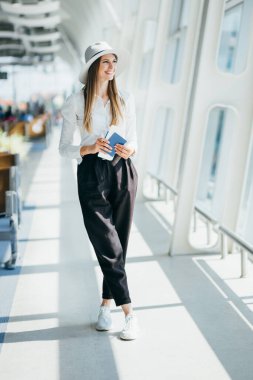 Seyahat Selfie 'sinin tadını çıkar. Şapkalı güzel bir kadın havaalanında beklerken selfie çekiyor..