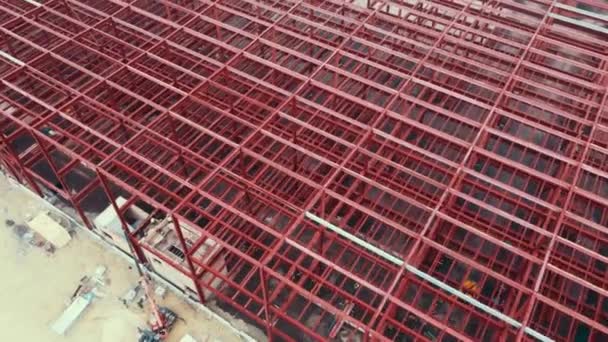 Construction of warehouse from metal structures. Industrial building on light gauge steel framing. Frame of modern hangar or factory. Aerial view of a construction site with steel structure warehouse. — Stock Video