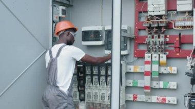 Elektrik mühendisi şebeke devrelerindeki güç voltajını kontrol ediyor. Elektrik Sistemleri Güç Dağıtım Kabinesi. Elektrik Mühendisi Testi Voltaj Akım Elektrik Hattını Ölçüyor.