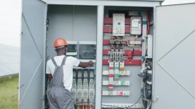 İnsan kavramı, bakım ve alternatif enerji. Elektrik Sistemleri Güç Dağıtım Kabinesi. Çok ırklı insanlar yeşil enerji üretim sürecini inceliyor. Güç dönüştürücü