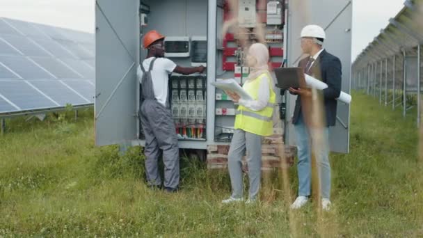 Multiracial people checking switchgear on solar station. Electrical Systems Equipment Power Distribution Cabinet. Multiracial people examining process of green energy production. Power transformer. — Stock Video