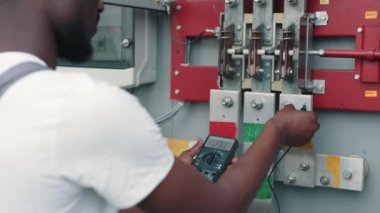 Elektrik mühendisi şebeke devrelerindeki güç voltajını kontrol ediyor. Elektrik Sistemleri Güç Dağıtım Kabinesi. Elektrik Mühendisi Testi Voltaj Akım Elektrik Hattını Ölçüyor.