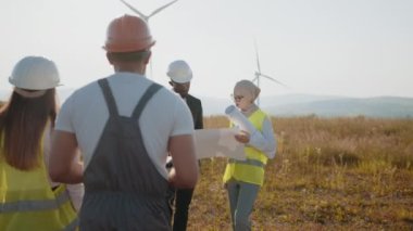 İş adamı ve ekibi güç üretim alanını araştırıyor. Bir grup profesyonel, temiz çevre dostu enerji üretmek için işbirliği yapıyor. Çevre dostu yenilenebilir rüzgar enerjisi kavramı.