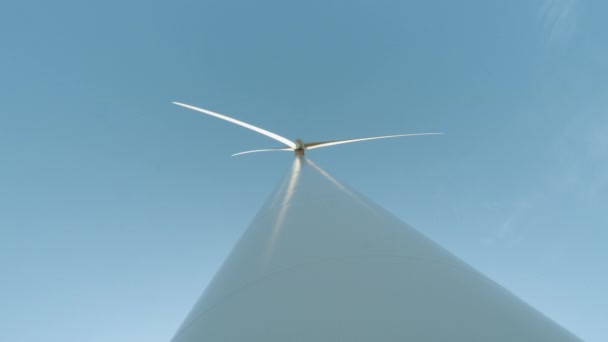 Concept van elektriciteitsproductie en schone energie. Windturbines met messen. Energieproductie met schone en hernieuwbare energie. Windturbines of windturbines op zonnige dag met blauwe lucht — Stockvideo