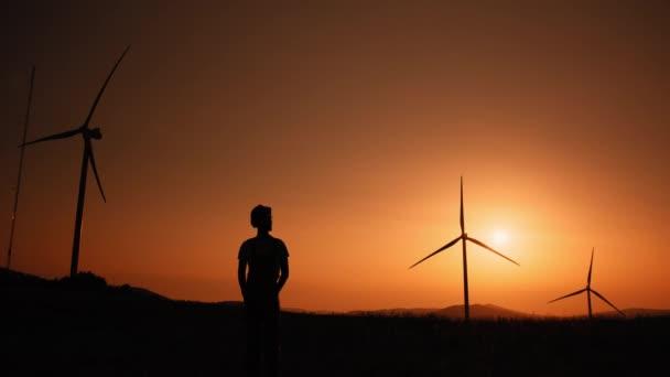 Silueta Muž Stojící Poli Obrovskými Větrnými Mlýny Během Letního Západu — Stock video