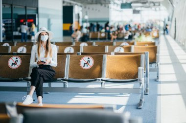 Uluslararası havaalanında bagajlı virüsü önlemek için maske takan bir kadın. Coronavirus ve Gripp 'e karşı koruma