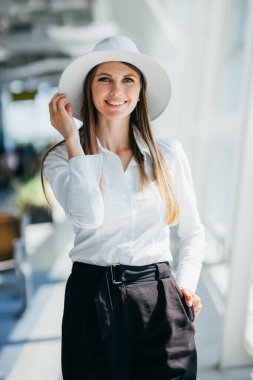 Kalkış salonunda poz veren bir kadın. 20-30 yaşlarında bir kadının portresi.