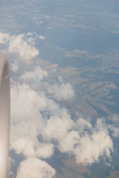 目的地までの大気の空に浮かんでいる間、商業用飛行機の窓の外の美しい空とジェットエンジンの眺め。曇り空の青い空。航空宇宙産業の概念. — ストック写真