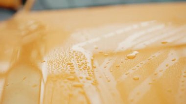 Yıkandıktan sonra arabaya su dök. Temizlikten sonra arabanın ön tarafı. Araba konsepti. Temiz araba konsepti. Dışarıda araba yıkama. Arabayı ovduktan sonra köpürmüş. Akan su damlalarını kapat