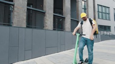Yemek teslimatı. Moto Scooter 'da yemek dağıtımı için akıllı telefon uygulaması kullanan profesyonel kurye. Kurye telefonundaki müşteri adresini kontrol ediyor, yemek teslimatı salgını. Hızlı teslimat.