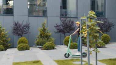 Termo çantalı ya da sırt çantalı genç teslimatçı kadının şehirde scooter sürerken, yemek dağıtırken tam boy görüntüsü. Kurye, teslimat hizmeti konsepti. Scooter 'a odaklan