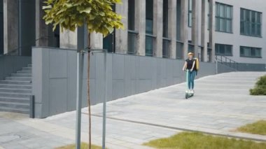 Termo çantalı ya da sırt çantalı genç teslimatçı kadının şehirde scooter sürerken, yemek dağıtırken tam boy görüntüsü. Kurye, teslimat hizmeti konsepti. Scooter 'a odaklan.