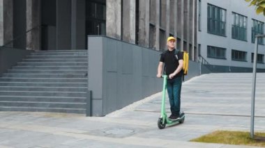 Motosikletli bir kurye, paket servis ve restoranlardan eve sıcak yemek teslimatı, yemek teslimatı ve çevrimiçi alışveriş konseptiyle şehre yemek getiriyor. Scooter 'la yemek getirdim.