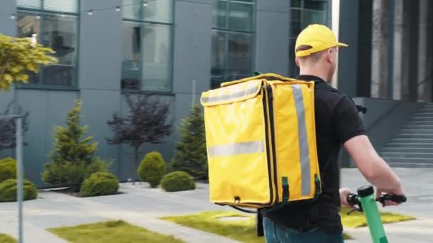 Essensausgabe. Courier Guy Delivery Restaurant Mahlzeiten in Box, posiert auf E-Motorrad im Freien. Porträt eines Zustellers. Lieferservice, Fast Food und People-Konzept — Stockvideo