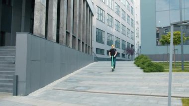 Sarı sırt çantalı bir teslimatçı, elektrikli motorsiklette yüz maskesi takıyor. Karantina sırasında mükemmel bir atış. İzotermal yiyecek kutusu olan kurye elektrikli scooterla geliyor.