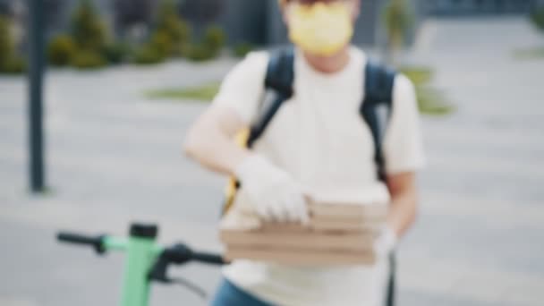 Pizzaleveranser. Oigenkännlig Leverans Man bär medicinsk mask och handskar med Pizza Box närbild. Delivery Man sträcker ut en hög med pizzalådor. Pizza leverans kurir som erbjuder pizza. — Stockvideo