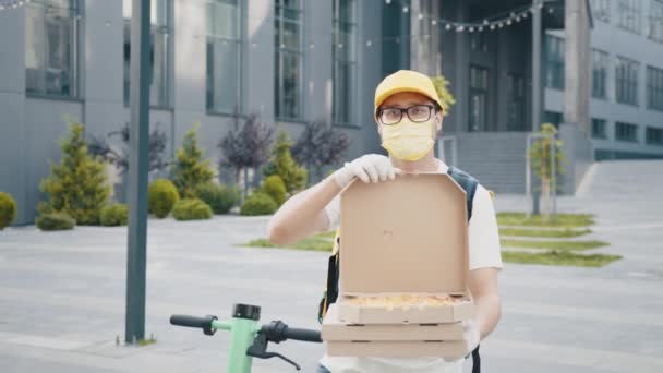 피자 배달. 의료용 마스크를 착용하고 피자 상자를 가까이 대고 장갑을 끼는 사람. 배달 맨 이 피자 상자를 쌓아 놓고 있습니다. 피자 배달원 이 박스 안에서 피자를 제공하는 모습. — 비디오