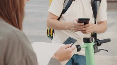 Müşteri siparişi ödemesi için teslimatçıya kredi kartı veriyor, seçici bir şekilde. Online mağazadan küçük bir paket geldi. Kadın paketi teslimatçıdan aldı..