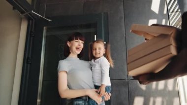 Bebekli güzel bir kadına yemek teslimatı. Kurye lezzetli pizzayla dolu bir kutu açar. Genç bir Afro-Amerikan kurye müşteriye sipariş veriyor. İnternetten yemek ve fast food sipariş et..