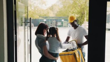 Küçük bir kızı olan genç bir kadın evinin kapısını açıyor ve Afro-Amerikan bir kuryeyle karşılaşıyor. Afrikalı-Amerikalı bir kurye, küçük bir kıza online bir mağazadan teslim edilmiş karton bir posta kutusu veriyor..