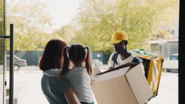 Paketi açarken, mutlu bir çocuk pofuduk bir oyuncak ayıyı kutudan çıkarır. Annesiyle birlikte evin kapısında duran küçük bir kız için bir paket taşıyan kurye. İnternetten e-ticaret mağazaları satın al