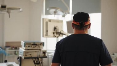 Kıdemli cerrah ameliyathaneye giriyor. Otantik ekipmanlı gerçek modern hastane. Cerrah ameliyat tekniğini hazırlar ve uygular. Operasyon için ekipman başlatılıyor