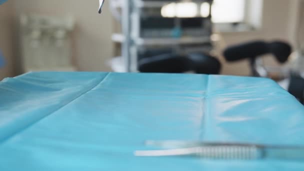 Una mesa de herramientas médicas se colocan sobre una mesa en preparación para la cirugía robótica. Herramientas quirúrgicas. Múltiples herramientas quirúrgicas en una placa en quirófano. Los doctores y la enfermera lo recogen. Medicina moderna — Vídeo de stock